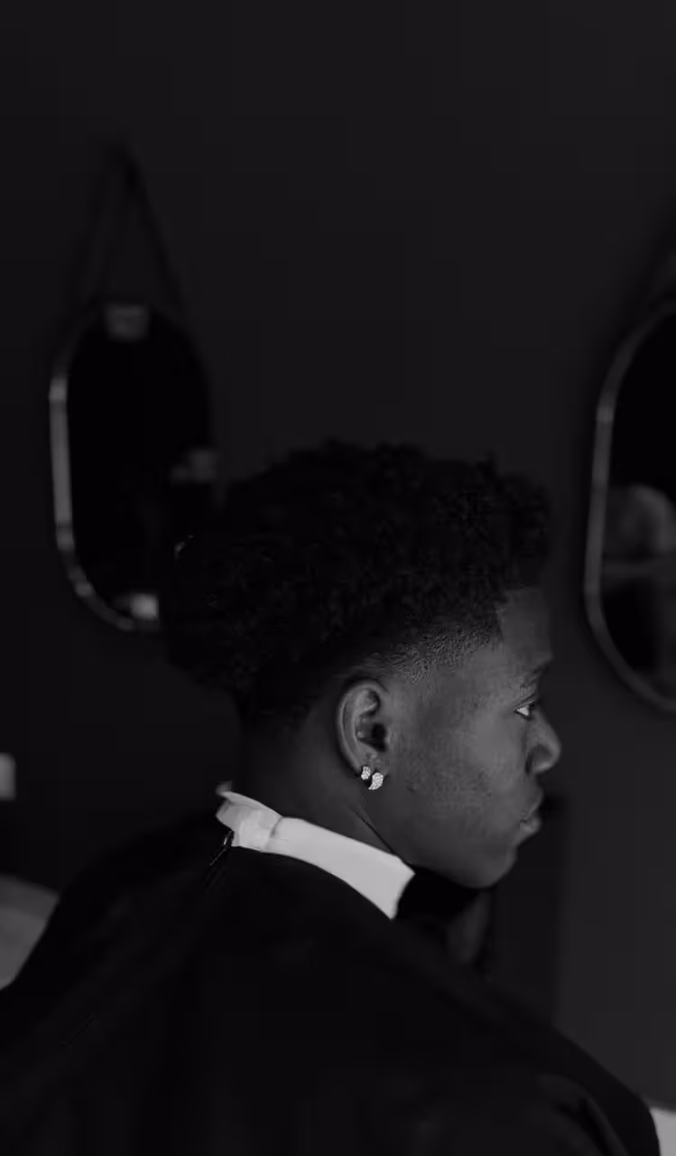 Corte alto e volumoso em cabelo crespo, com degradê fechado nas laterais